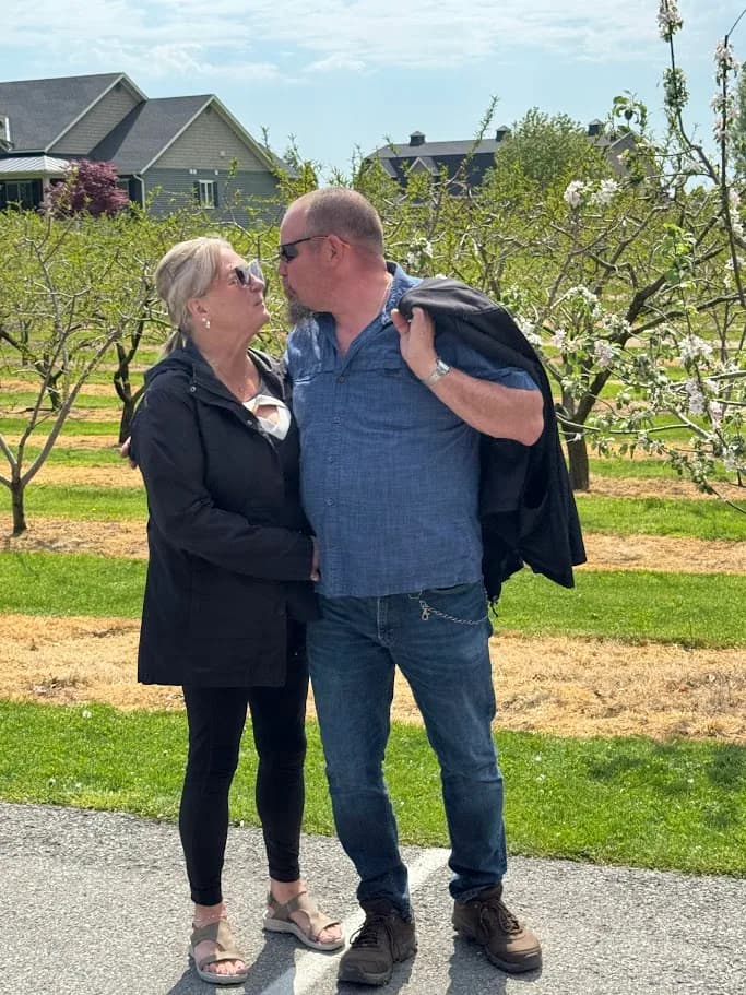 Couple sharing a relaxed moment among flowering orchard trees